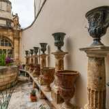 Lungo il perimetro 12 colonnine reggono altrettanti vasi in ceramica con figure classicheggianti, alternati ad altri in pietra
